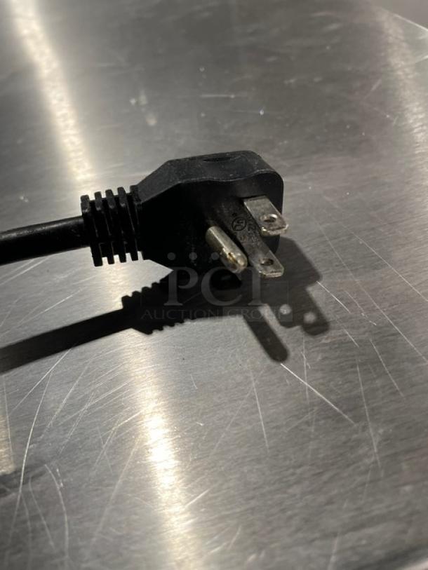 Alt text: Close-up of a power plug on a stainless steel surface for Arctic Air Model AUC60RZ cooler.