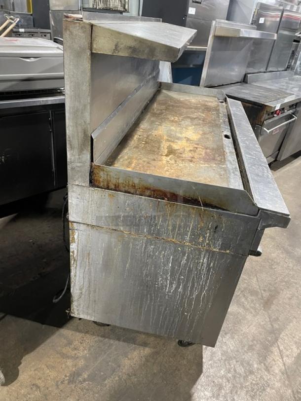 Garland H280 stainless steel flat griddle range/double oven combo with overhead shelf and back/side splash, on casters.