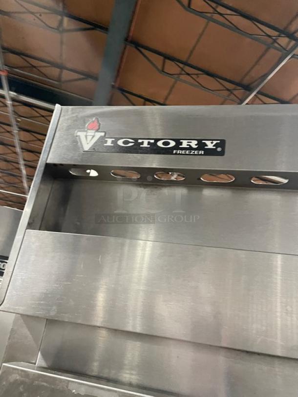 Victory commercial stainless steel 3-door reach-in freezer with poly-coated wire rack and casters. Visible Victory logo.