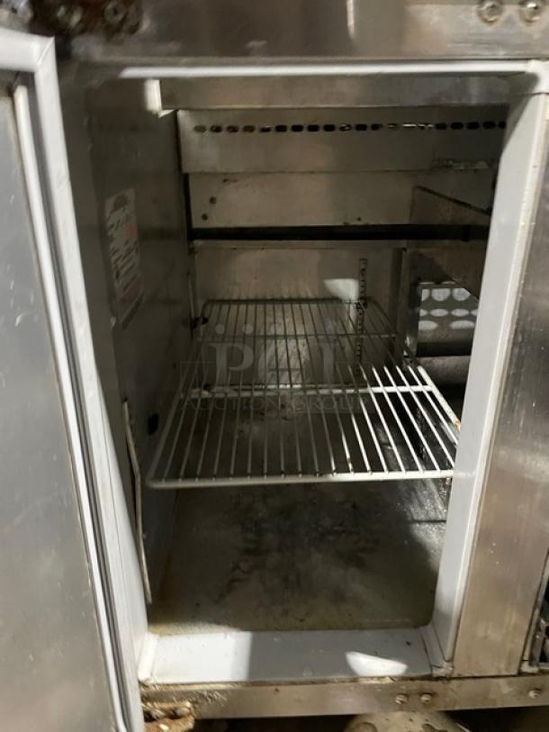 Continental stainless steel refrigerated salad prep table with single door, three drawers, poly coated wired rack, on casters.