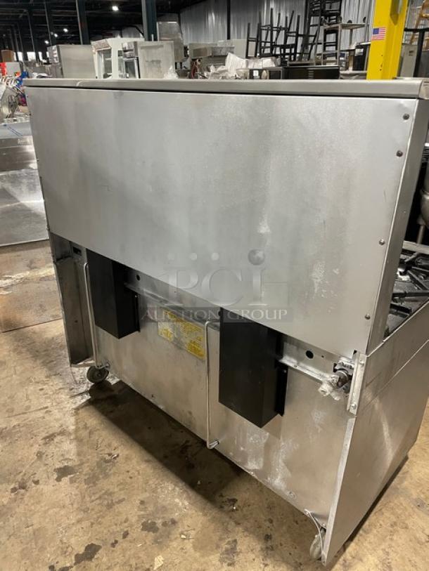 Garland Model H284 stainless steel 10-burner range with double oven, backsplash, wired rack, and casters. Natural gas powered.