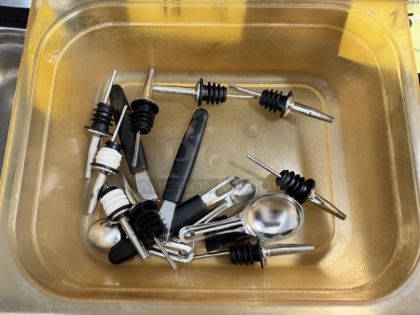 Lot of miscellaneous bar tools, including pour spouts and measuring spoons, in used condition.