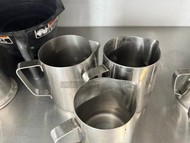 Lot of 3 stainless steel milk frothing pitchers, 20oz each, with handles and spouts, in good used condition.
