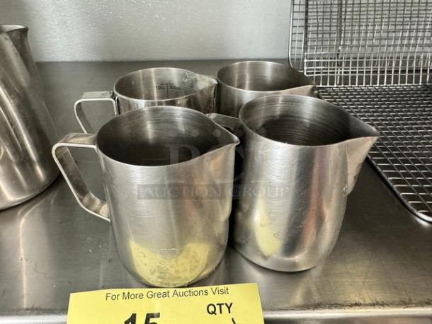 Lot of four 10oz stainless steel milk frothing pitchers. Slightly worn condition. Ideal for baristas or coffee enthusiasts.