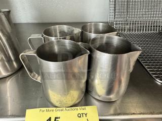 Lot of four 10oz stainless steel milk frothing pitchers. Slightly worn condition. Ideal for baristas or coffee enthusiasts.