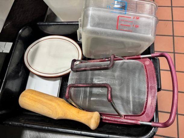 Lot of miscellaneous kitchenware including a mesh strainer, wooden handle tool, and measuring container. Good condition.