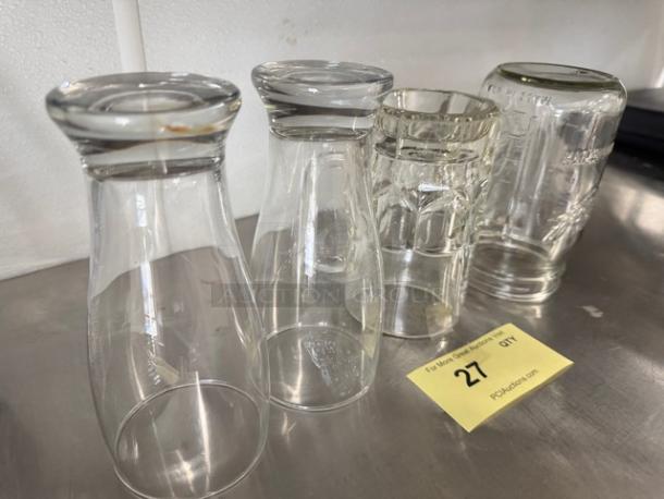 A lot of 4 miscellaneous clear glass vessels on a table, varying shapes and sizes, overall good condition.