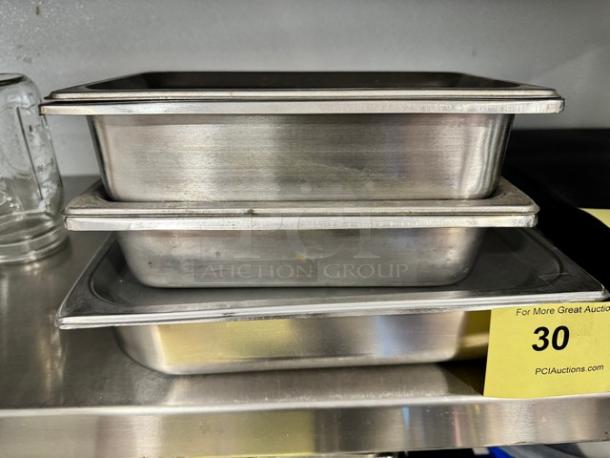 Stacked stainless steel pans with lids, model BIDX3. Slightly used, minor scratches. Auction tag 30 visible.