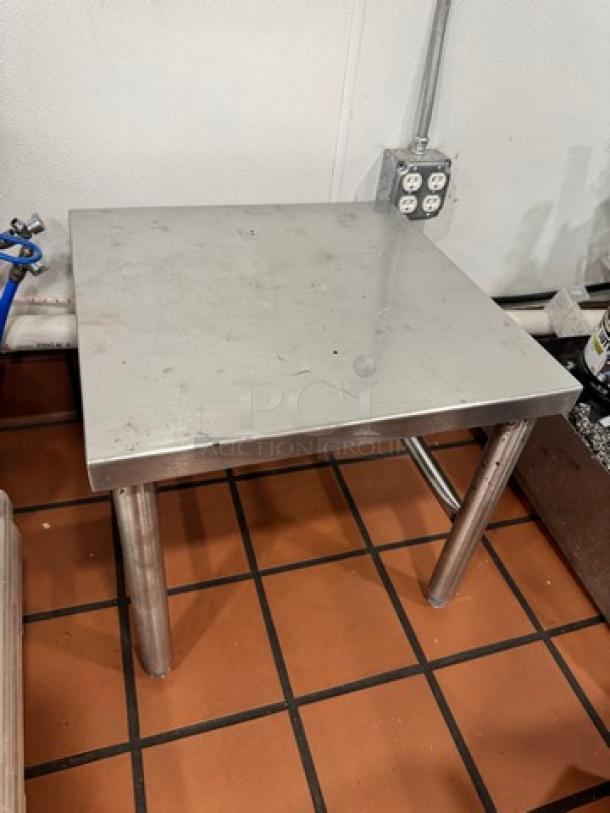 20" stainless steel stand with square top, sturdy legs, minor surface scratches, ideal for industrial use.