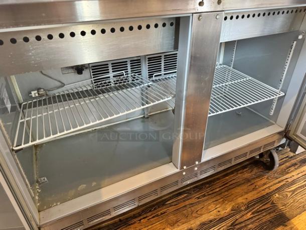 Beverage-Air SPE48-18M 48" prep table, stainless steel, dual shelves, on casters, used condition, 115V, visible interior wiring.