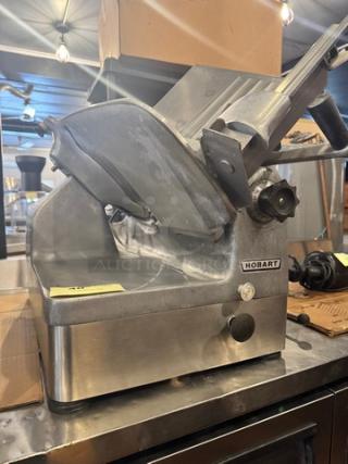 Hobart 1712 Commercial Meat Slicer, 115V; stainless steel, used condition, visible Hobart branding.