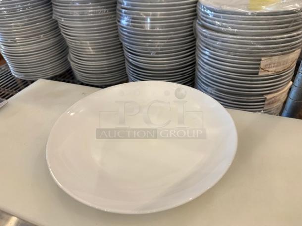 9.25" white coupe lunch plate, brand new condition, stacks of plates visible in the background.