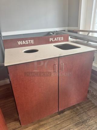 Wooden waste receptacle with dual compartments labeled "WASTE" and "PLATES," featuring a countertop with two openings.