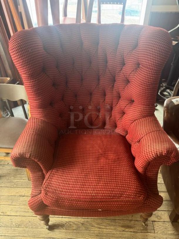 Vintage wingback armchair with red checkered upholstery, tufted back, rolled arms, and wooden legs. Good condition.