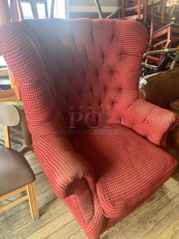 Vintage wingback armchair with red and black checked upholstery, button tufting, and curved armrests. Good condition.