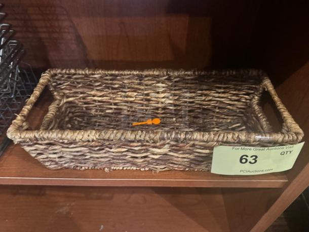 Woven rectangular basket with natural fibers, sturdy design. Item 63 label attached. Suitable for storage or decor.