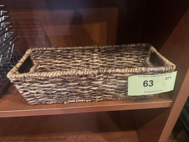 Rectangular woven basket with handles, brown tones, in good condition. Auction label indicates lot number 63.