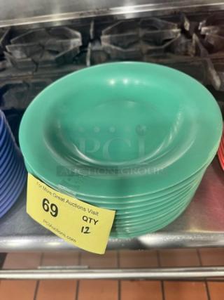 Stack of green Melamine plates BIDX12, in good condition. Visible auction tag indicates quantity of 12.