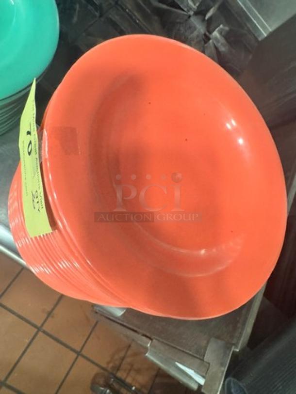 Red melamine plate, model BIDX20, in stack. Bright color, glossy finish, used condition. Visible auction tag.