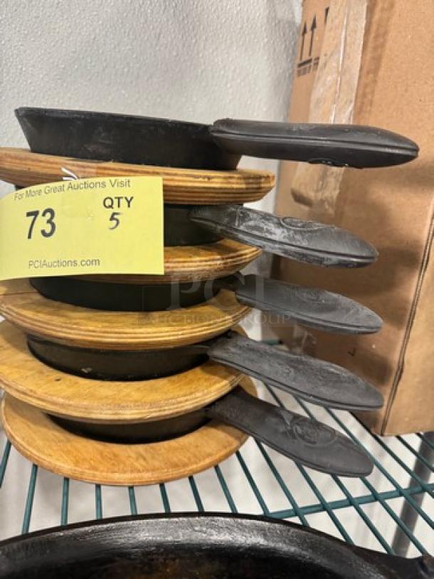 5" cast iron skillet BIDX5, stack of 5, with wooden trivets, in good condition, auction lot tag 73, QTY 5.