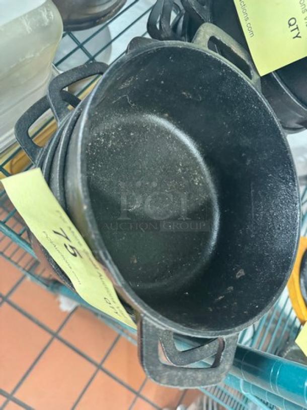 Small cast iron Dutch oven without lid, visible wear, two handles, marked with auction ID BIDX4, size medium.