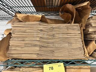 Stack of Duro 1/6 paper sack bags on a shelf, brown color, neatly stacked, yellow auction tag showing "78".