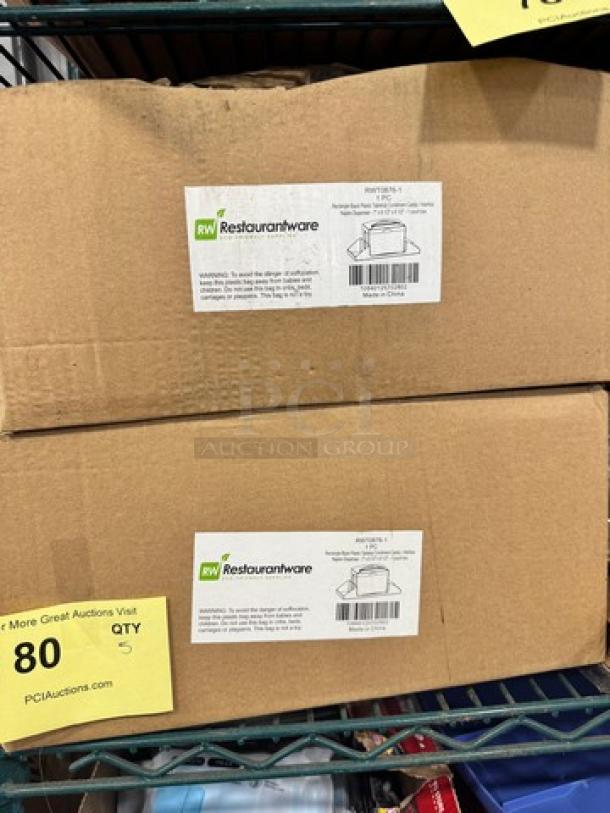 Two boxes labeled "RW Restaurantware" containing rectangle black plastic tabletop condiment caddy-napkin dispensers, model BIDX5.