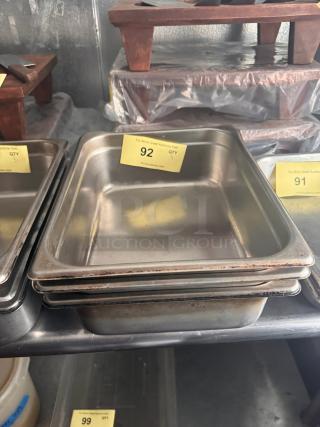 Stainless steel food pan BIDX3, stackable, used condition, visible wear, yellow auction tag "92" indicating lot number.