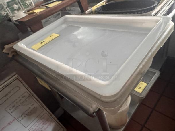 Plastic food storage container with lid, stacked, clear, rectangular shape, clean condition, labeled "94" in auction setting.
