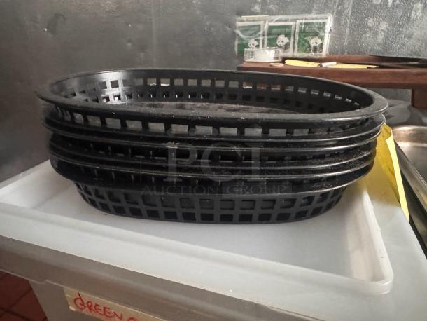 Lot of 6 black plastic food baskets in used condition, stacked on a white surface, ideal for restaurant use.