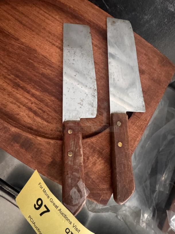 Lot of 2 vintage cleaver knives with wooden handles; visible wear on blades. Auction tag number 97 included.