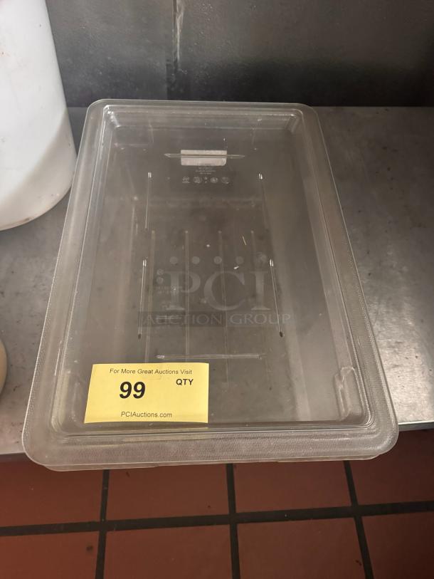 Clear plastic food storage container with lid, in good condition. Markings on lid indicate capacity. Auction lot 99 label visible.