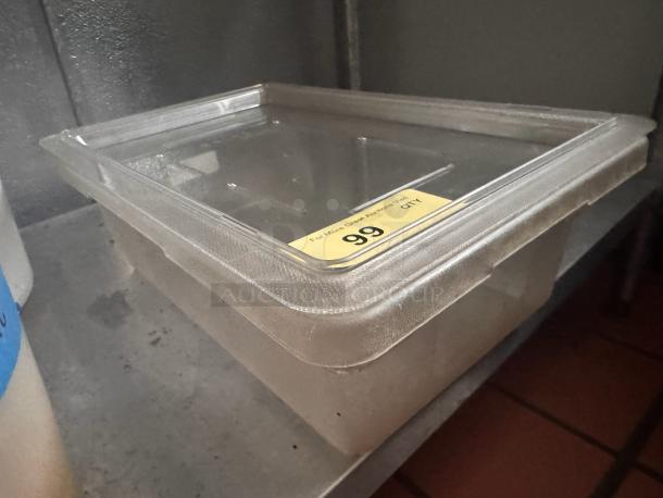 Clear plastic food storage container with lid. Tag indicates auction item number 99. Slightly worn condition.