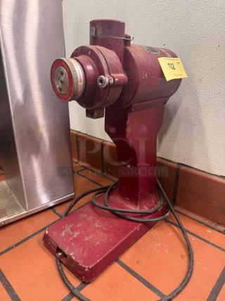 Tomlinson CM-400 commercial coffee grinder, red, adjustable grind dial, fair condition with visible wear, attached cord.