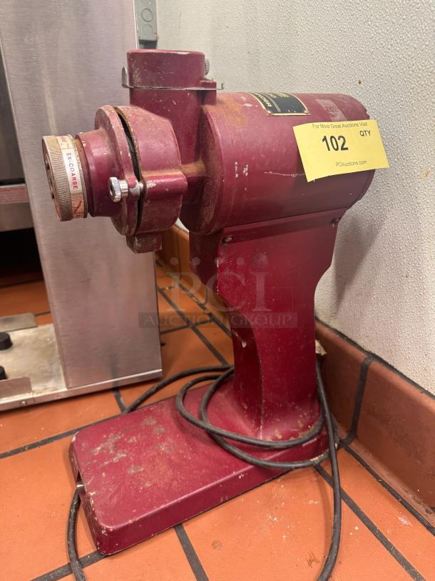 Tomlinson CM-400 commercial coffee grinder in used condition, red body, visible wear, with grind setting labeled "ex-coarse."