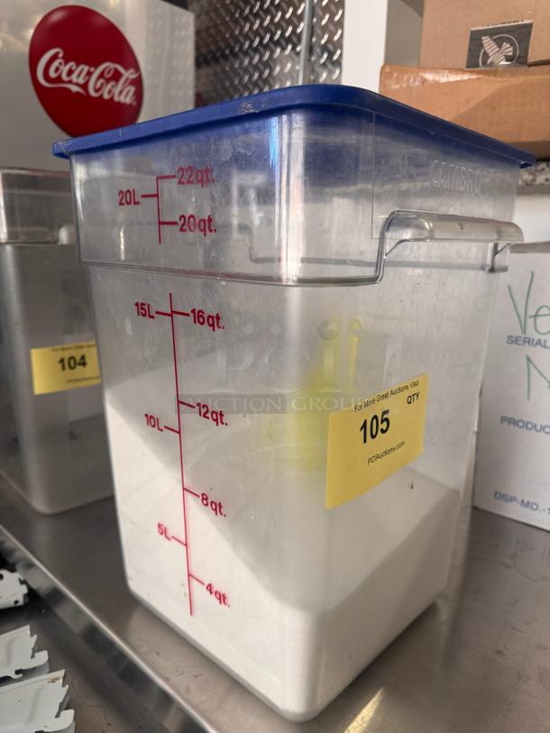 22 Quart clear square food storage container with marked measurements, blue lid, and a yellow auction tag labeled "105".