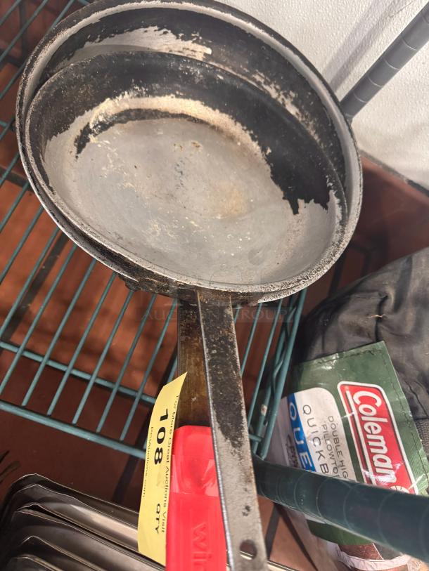 Lot of 2 vintage skillets with worn surfaces and patina, auction tag number 108 visible, offered as one lot.
