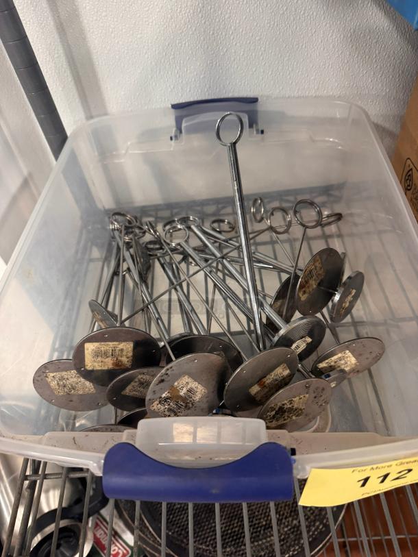 Lot of metal card holders in a plastic bin, used condition, with labels on bases indicating wear.