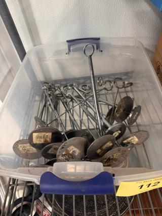 Lot of metal card holders in a plastic bin, used condition, with labels on bases indicating wear.