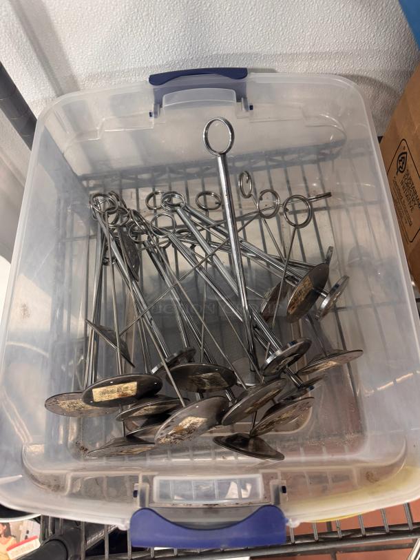 Lot of metal card holders in a plastic bin, used condition. Circular bases, with some visible wear and markings.