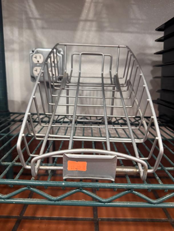 Metal wire counter display BIDX3, used condition, with price tag reading $1.99, on a metal shelf.