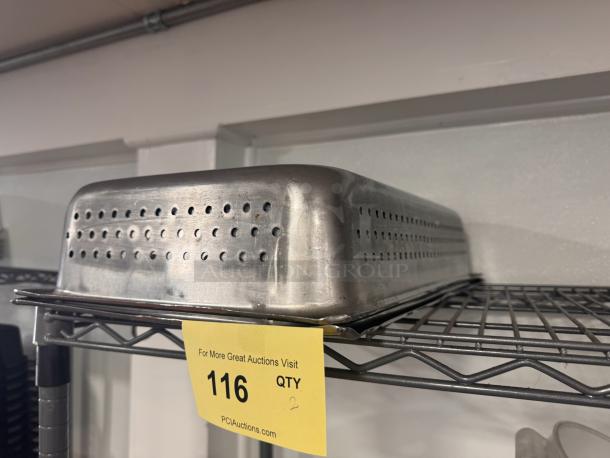 Perforated stainless steel food pan on metal shelf, showing light wear. Auction tag visible, marked "116, QTY 2."