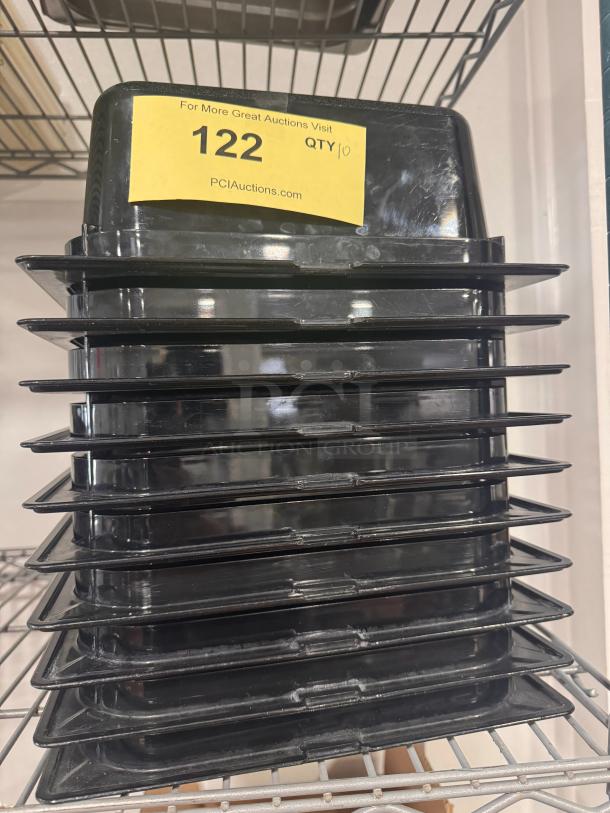 Stack of black plastic food pans BIDX10, quantity 10, in good condition. Auction label with lot number 122.