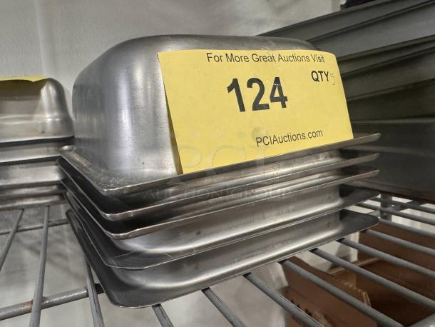 Stainless steel food pan BIDX5, stackable, good condition, quantity 5. Auction label reads "124, QTY 5" from PCI Auctions.