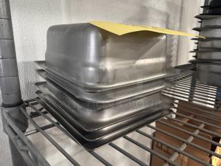 Stainless steel food pan BIDX5, stackable, good condition, on metal shelf. Features durable construction and minor wear.