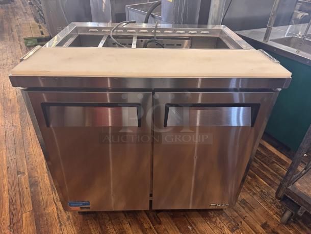 Turbo Air MST-36 prep-table in stainless steel, featuring a top workspace and storage doors below. Visible quality label.