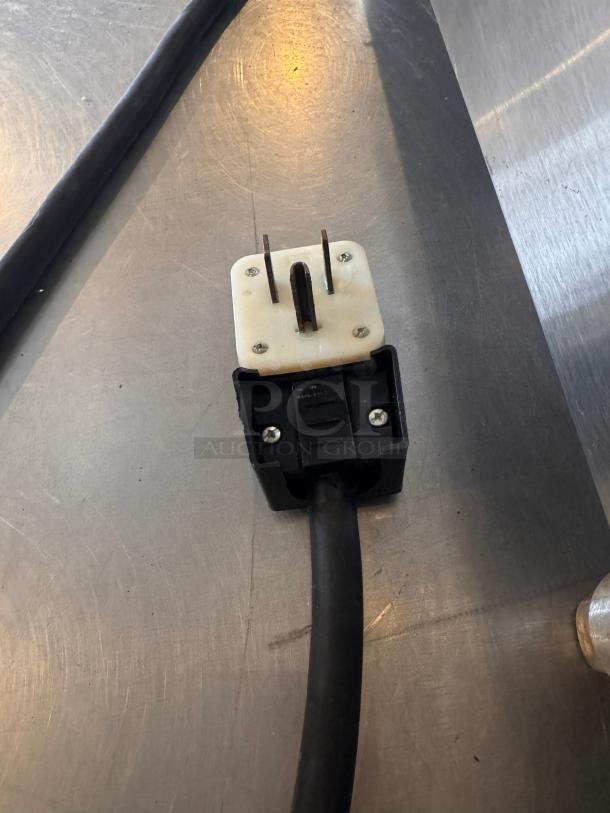 Power plug of a Star Ultra-Max 24" countertop electric griddle, showing prongs and cord on a stainless steel surface.