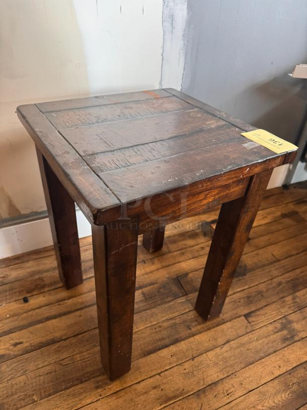 Dark wood side table with a rustic finish, visible scratches, and sturdy square legs. Tag reading "136" is attached.