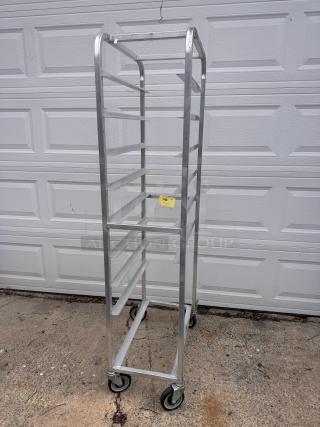 Aluminum cooling rack with multiple shelves, caster wheels, and a label marked "140" for auction. Good condition.