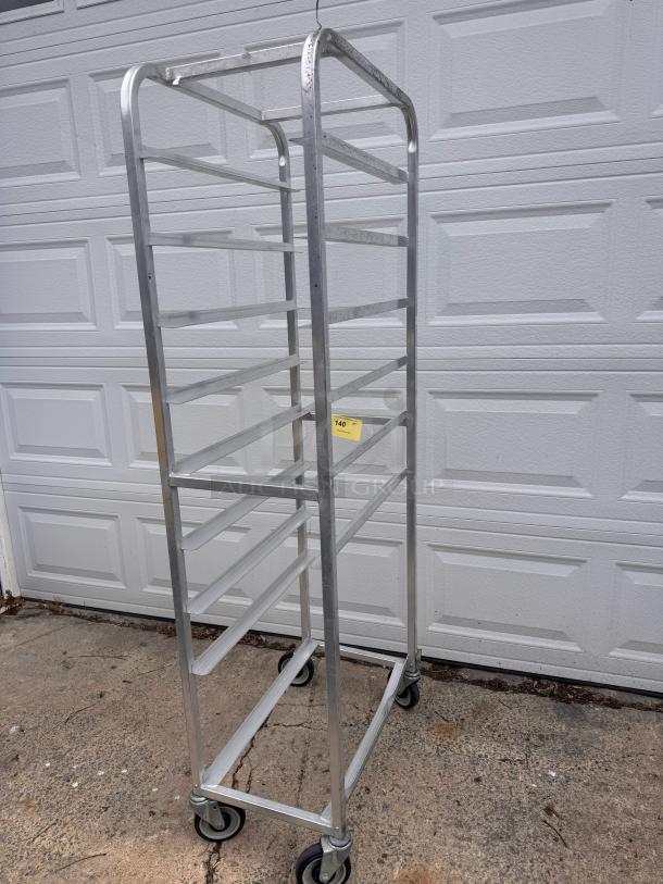 Aluminum cooling rack with multiple shelves, on casters. The rack is in good condition with a label indicating auction number 140.